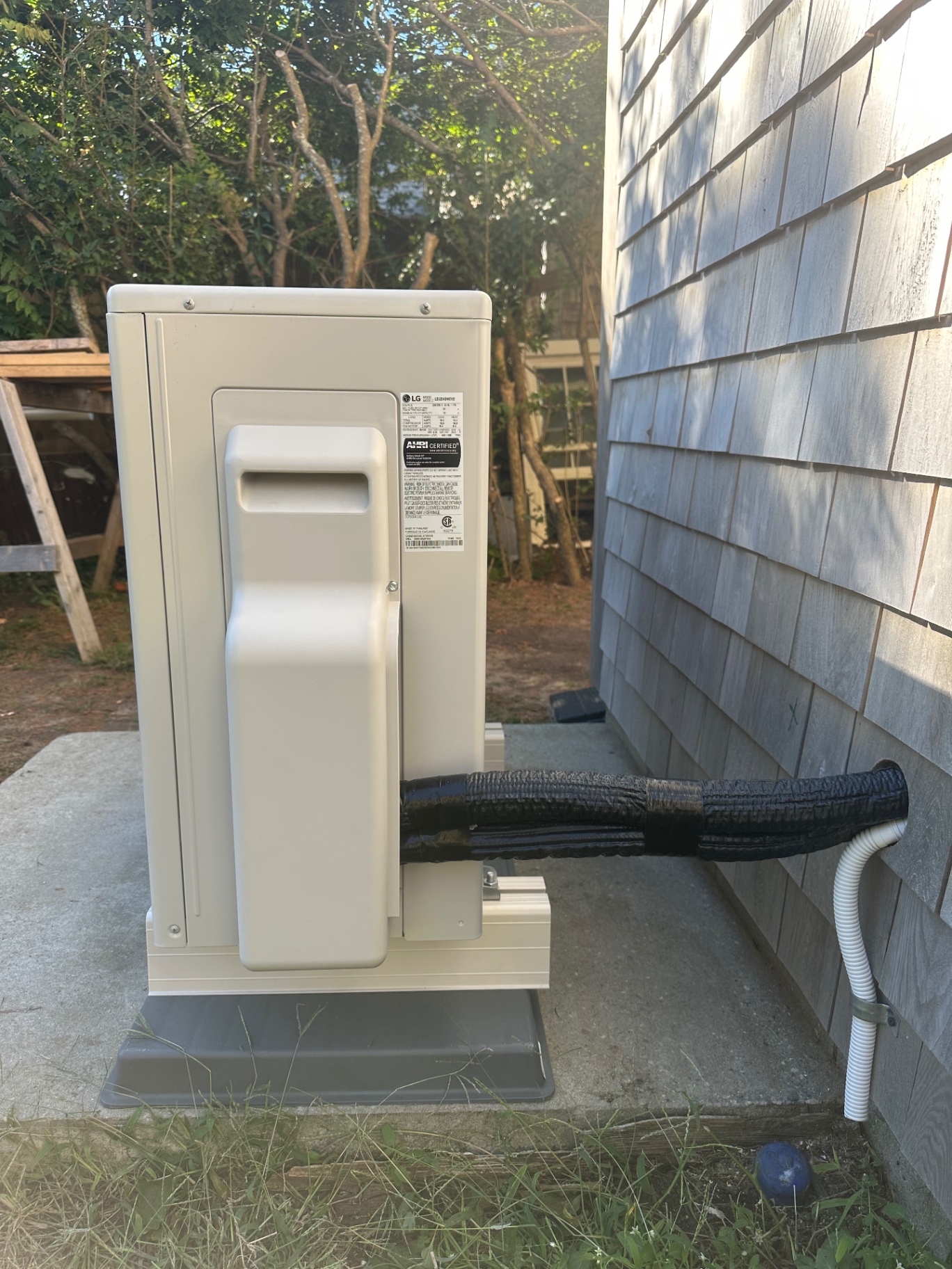 LG mini-split outdoor unit with insulated lineset into shingled wall