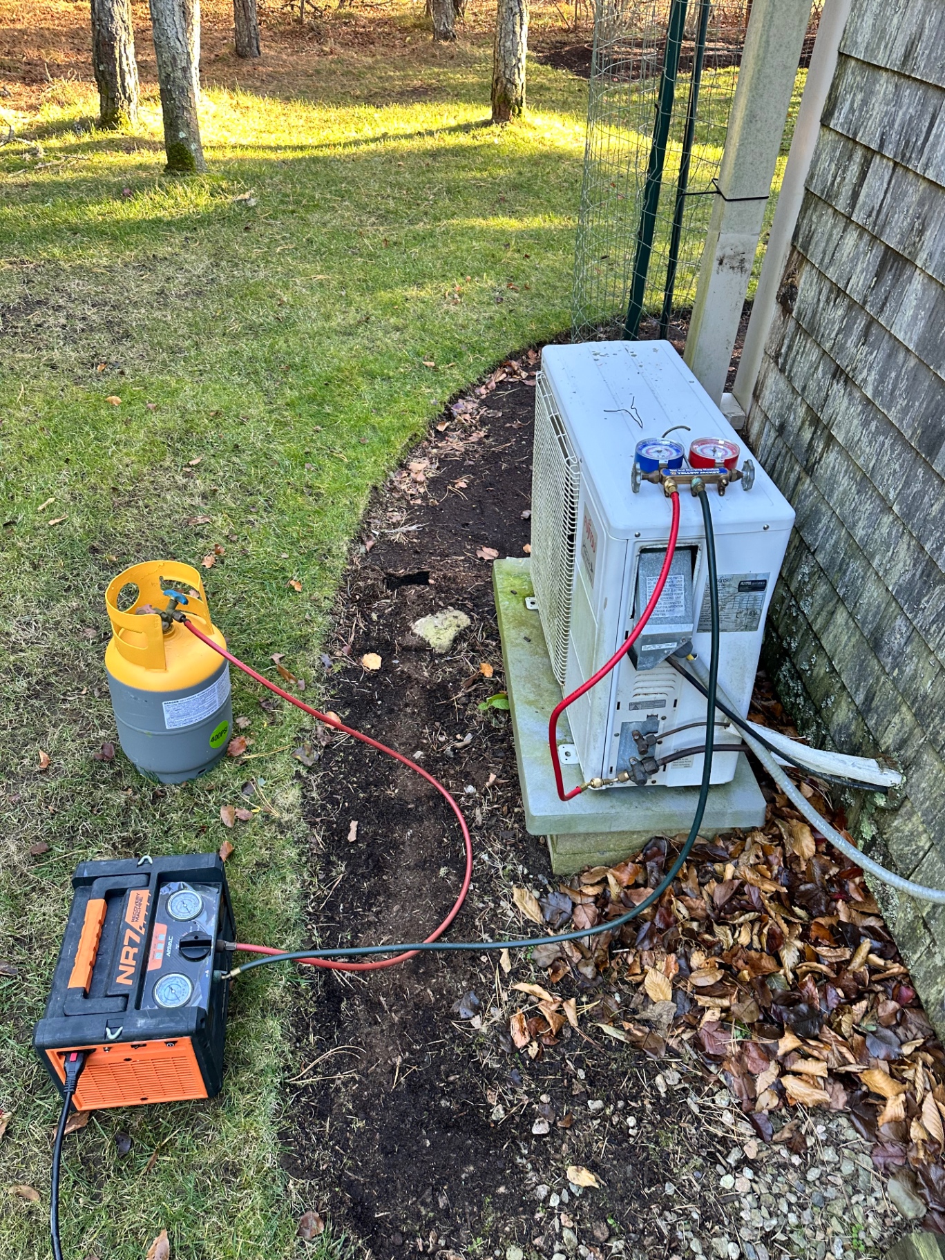 AIRTECH technician performing refrigerant recovery on a heat pump